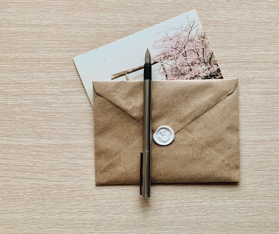 Picture of an envelope, card and fountain pen.