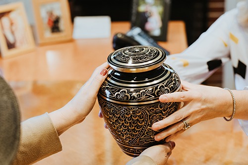 One person passing an urn to the other person